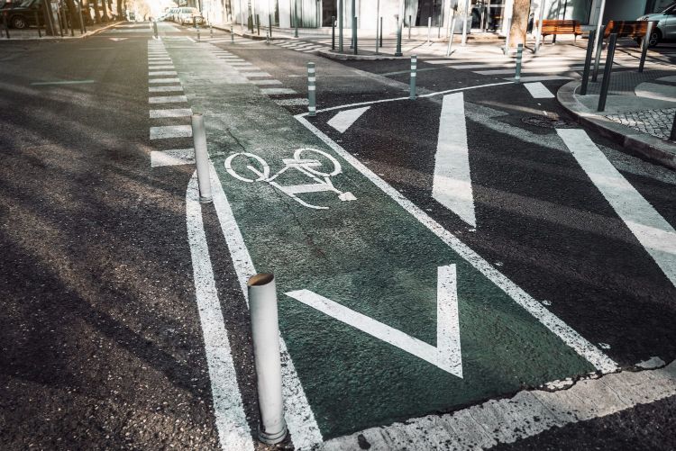 A green painted cycle lane with a white painted bicycle road marking, surrounded by a zebra crossing and a road.